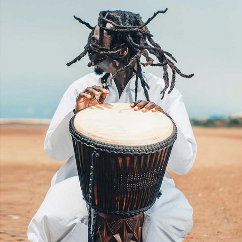 Ein Jamaikaner trommelt auf einer Trommel