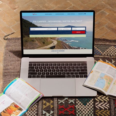 Buchungsportal TUI CAMPER Mockup Laptop mit Reiseführern mit dem Buchungsportal TUI CAMPER
