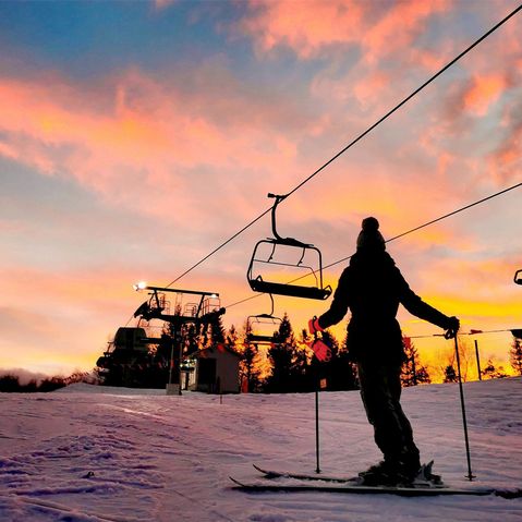 Winterberg im Winter bei Sonnenuntergang mit Skilift und einem Skifahrer