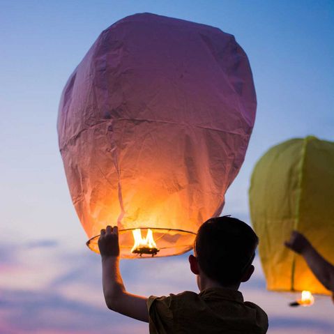 Ein Junge lässt in Thailand ein Ballon steigen