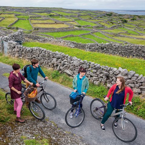 Mehrere Radfahrer unterhalten sich am Wegrand einer Straße in Irland