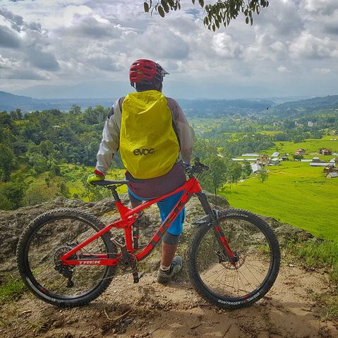 Travelbike.jpg Mann lehnt an Fahrrad und genießt die Aussicht
