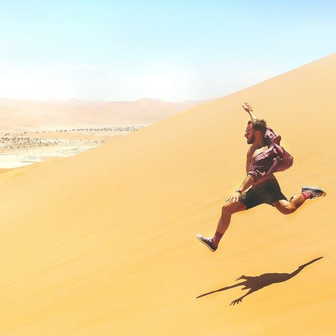 Mann rennt Sanddüne in Namibia runter