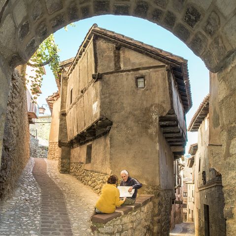 Altes Ehepaar liest Buch vor spanischem Haus in Aragón