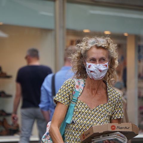 Frau mit Maske in Einkaufszone