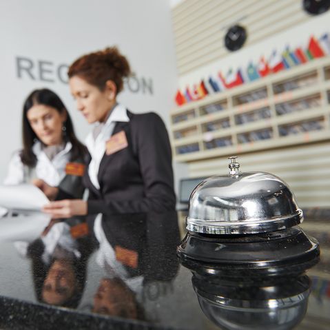 Hotel Auszubildende lernt den Ablauf an einer Rezeption