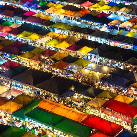 Ein Thailändischer Nachtmarkt mit bunten beleuchteten Zelten von oben